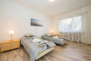 a bedroom with two beds and a window at On the Lake 2BR with Garage in Porto Ronco - Happy Rentals in Ronco sopra Ascona