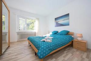 a bedroom with a bed with a blue comforter at On the Lake 2BR with Garage in Porto Ronco - Happy Rentals in Ronco sopra Ascona