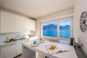 a kitchen with a view of the water and mountains at On the Lake 2BR with Garage in Porto Ronco - Happy Rentals in Ronco sopra Ascona