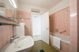 a bathroom with a sink and a tub and a toilet at On the Lake 2BR with Garage in Porto Ronco - Happy Rentals in Ronco sopra Ascona