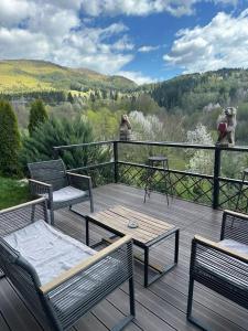 a deck with two chairs and a table on a balcony at Green Yard Doftana in Teşila