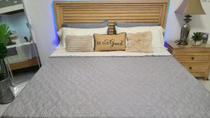 a bed with a gray comforter and pillows on it at Lorenton Hideaway Studio in Lucea