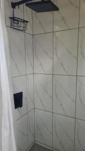 a shower with white marble walls and a shelf at Lorenton Hideaway Studio in Lucea