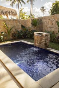a pool with a water fountain in a backyard at Seraya Villas in Kuta Lombok