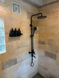 a shower in a bathroom with a stone wall at Seraya Villas in Kuta Lombok