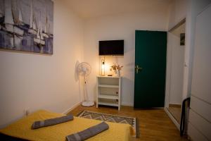 a room with two beds and a fan and a green door at Casa Nora in centre of Vodnjan - Happy Rentals in Vodnjan