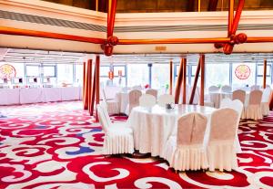 a banquet hall with white tables and white chairs at Golden Inns Beijing South Railway金泰之家北京南站店 in Beijing