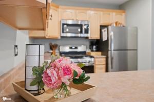 a kitchen with a vase of pink flowers on a table at Alyeska Mountain Side Retreat! in Girdwood