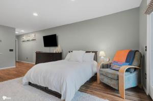a bedroom with a bed and a chair and a television at Alyeska Mountain Side Retreat! in Girdwood +10 photos