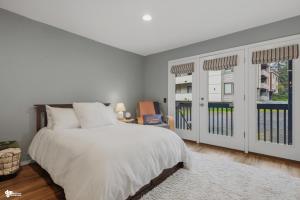 a white bedroom with a bed and two windows at Alyeska Mountain Side Retreat! in Girdwood