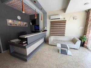 a living room with a couch and a chair at Hotel Sai Krish Grand Pallavaram in Chennai