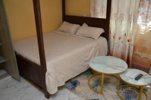 a small bedroom with a bed and a table at Maria Villa Studio in Voi