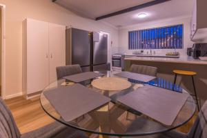 a kitchen with a glass table and some chairs at The Stapleton in Kalgoorlie +10 photos
