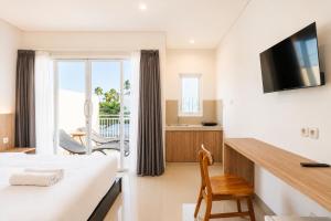 a hotel room with a bed and a desk at Double A Cozy Living in Canggu