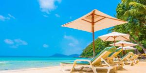 a group of chairs and umbrellas on a beach at Khu tham quan du lịch in Nam Tu Liem