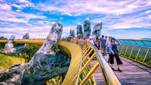 a group of people crossing a bridge with their hands up at Khu tham quan du lịch in Nam Tu Liem
