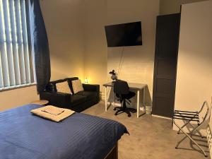 a bedroom with a bed and a couch and a desk at The Stapleton in Kalgoorlie