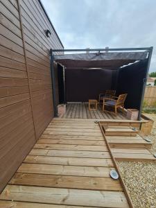 a wooden deck with two chairs and a table at Tiny House - Studio in Eygurande-et-Gardedeuil