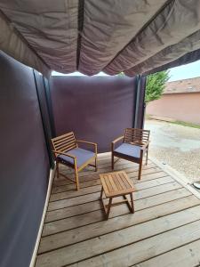 two chairs and a table on a wooden deck at Tiny House - Studio in Eygurande-et-Gardedeuil