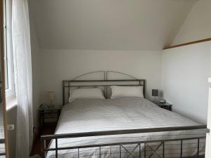 a bed in a white room with two night stands at Auszeit im Hunsrück in Braunshorn