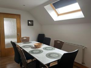 a dining room with a table with chairs and a skylight at Auszeit im Hunsrück in Braunshorn