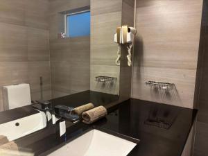a bathroom with a sink and a phone on the wall at Mazarin Hiriketiya in Dickwella