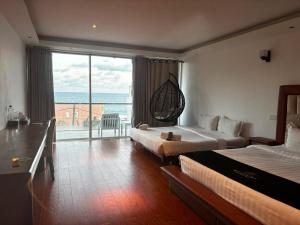 a hotel room with two beds and a large window at Mazarin Hiriketiya in Dickwella