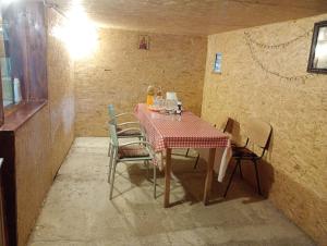 a dining room table with chairs and a red and white table cloth at Rustic House in Costeşti