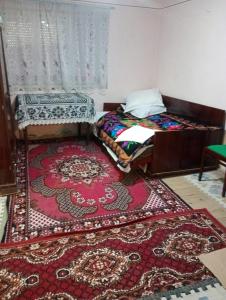 a room with two beds and a rug on the floor at Rustic House in Costeşti