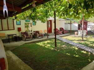 a yard with chairs and a table and a tree at Rustic House in Costeşti