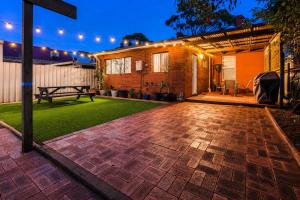 a patio with a bench and a house with lights at The Stapleton in Kalgoorlie