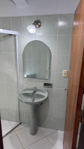 a bathroom with a sink and a mirror at Pousada Akros in Asunción