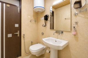 a bathroom with a sink and a toilet and a mirror at Palette Hotel Regency Valley View Pahalgam By CheckIn in Batakūt