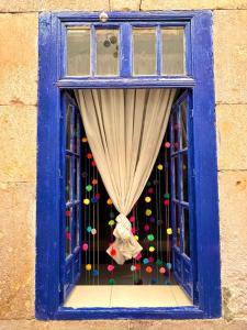 a blue window with a curtain and some balls at La Casa Azul Hostal in Morelia