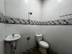 a bathroom with a toilet and a sink at Cio Adventure Hotel in Berastagi