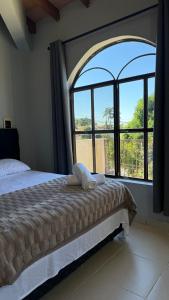 a bedroom with a bed and a large window at Pousada Akros in Asunción