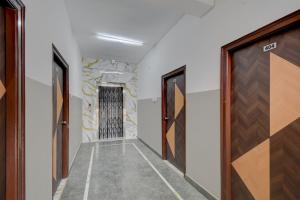 a corridor with doors and a stone wall at Super Hotel O Gandimaisamma Thalli Temple Formerly GN Luxury Suits in Dhundgol