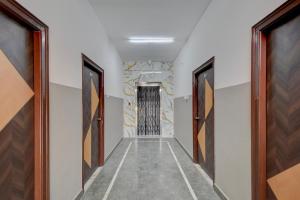 a hallway with two doors and a stone wall at Super Hotel O Gandimaisamma Thalli Temple Formerly GN Luxury Suits in Dhundgol +26 photos