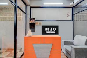 an office with an orange counter with a hotel sign on it at Super Hotel O Gandimaisamma Thalli Temple Formerly GN Luxury Suits in Dhundgol