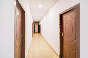 a hallway with a wooden door and a long corridor at Hotel O Jankipuram Vikas Nagar in Lucknow +22 photos