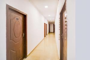 an empty hallway with a wooden door and a hallwayngth at Hotel O Jankipuram Vikas Nagar in Lucknow