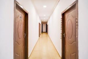 a corridor with two doors and a long hallway at Hotel O Jankipuram Vikas Nagar in Lucknow