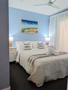 a bedroom with a large bed with a blue wall at Mayers Cottage in Perwillowen
