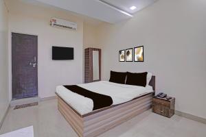 a bedroom with a bed and a tv on the wall at Collection O Iskcon Aurangabad Formerly Everest Inn in Chikalthān +63 photos