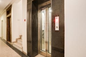 a hallway of a building with a glass door at Collection O Gol Park Atala in Prayagraj +25 photos
