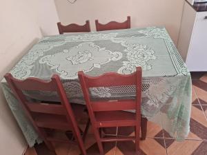 a dining room table with two chairs and a table cloth at Recanto feliz in São Thomé das Letras