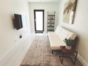 a living room with a white couch and a table at Zone T & A Escape in Fort Lauderdale