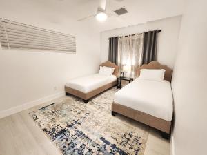 a bedroom with two beds and a rug at Zone T & A Escape in Fort Lauderdale