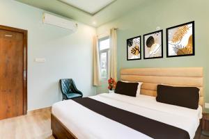 a bedroom with a large bed and a chair at Super Hotel O Gomti Nagar Vigyan khand in Lucknow