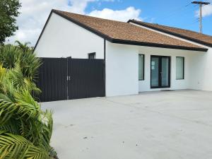 a white house with a black fence at Zone T & A Escape in Fort Lauderdale
